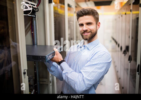 Technician removing server from rack mounted server Stock Photo