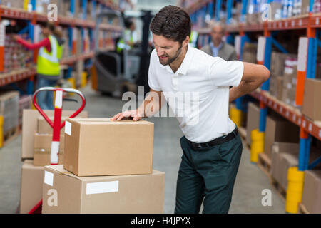 Male worker suffering from back pain while working Stock Photo
