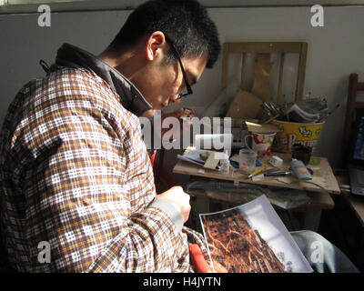 Jinan, Jinan, China. 16th Oct, 2016. Jinan, CHINA-March 15 2014: (EDITORIAL USE ONLY. CHINA OUT)Li Shousheng makes model of Lijiashan Village in his studio in Jinan, capital of east China's Shandong Province, March 15th, 2014. Li Shousheng, a young folk craftsman living in Jinan, capital of east China's Shandong Province, has made more than 30 series of architecture models including models of old Jinan Railways Station and Qingdao Cathedral since 2008. Li said that he enjoyed the process of making the models, inheriting traditional folk handicrafts. © SIPA Asia/ZUMA Wire/Alamy Live News Stock Photo