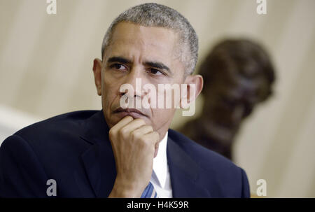 Washington, District of Columbia, USA. 17th Oct, 2016. United States President Barack Obama looks on during the release of the Cancer Moonshot Report in the Oval Office of the White House on October 17, 2016 in Washington, DC. Credit: Olivier Douliery/Pool via CNP Credit:  Olivier Douliery/CNP/ZUMA Wire/Alamy Live News Stock Photo