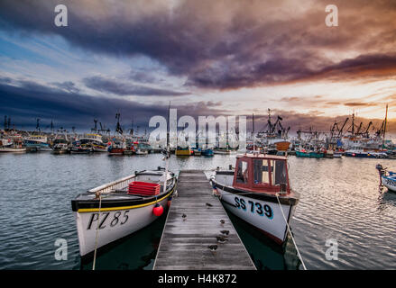 Newlyn, Cornwall, UK. 18th October 2016. UK Weather. The sun rises behind the clouds over Newlyn harbour. The night before fishermen from across the south west attended a meeting organised by Fishing for Leave founder Aaron Brown to discuss Brexit and the future of the British fishing industry. Credit:  Simon Maycock/Alamy Live News Stock Photo