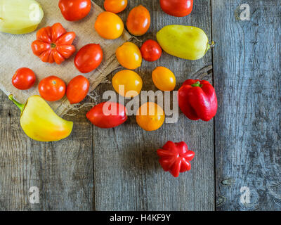 Juicy tomato, bell and  hot chili pepper on the wooden table top view Stock Photo
