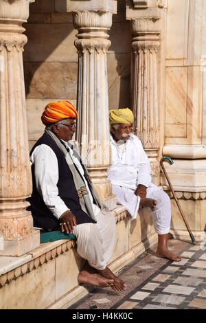 Two indian men sitting outside Karni Mata rat temple in Deshnoke (Bikaner), Rajasthan, India Stock Photo