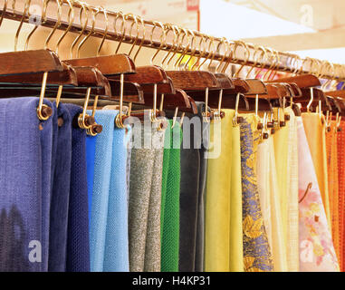 many hangers with woven fabrics and tablecloths on sale Stock Photo