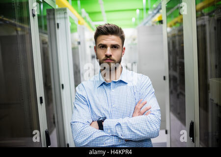 Technician standing with arms crossed in a server room Stock Photo