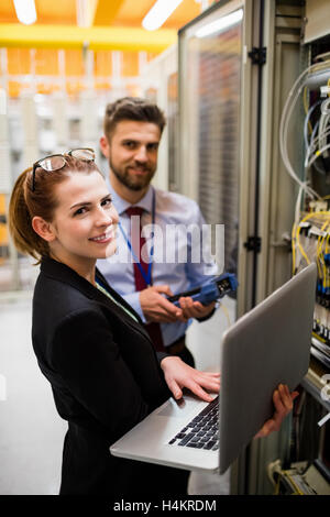 Technicians using laptop while analyzing server Stock Photo