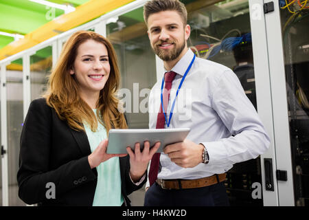 Technicians standing in server room with digital tablet Stock Photo