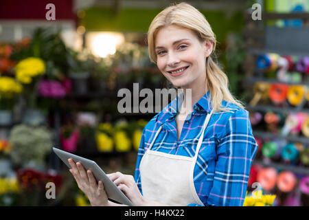 Smiling female florist using digital tablet Stock Photo