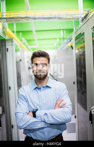 Technician standing with arms crossed in a server room Stock Photo