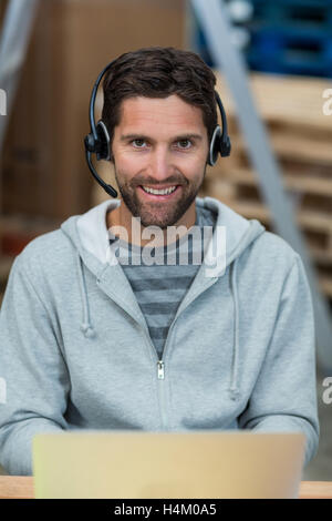 Man using laptop in warehouse Stock Photo