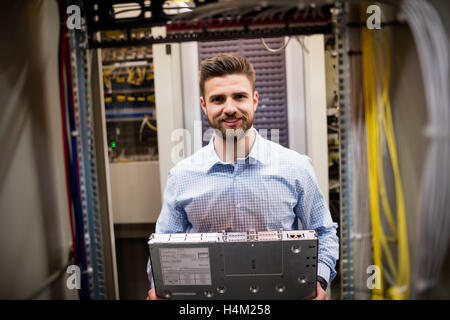 Technician removing server from rack mounted server Stock Photo