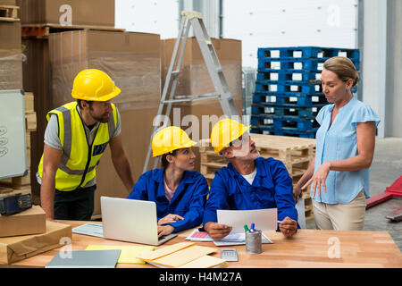 Warehouse workers discussing with manager Stock Photo