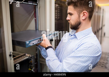 Technician removing server from rack mounted server Stock Photo