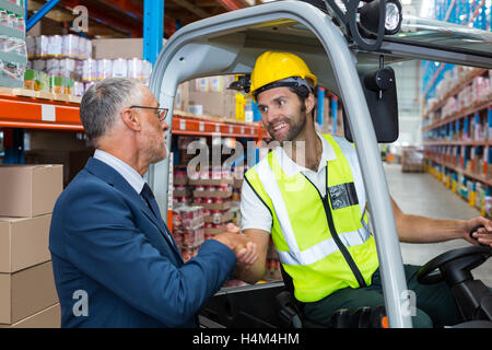 Warehouse worker shaking hands manager Stock Photo