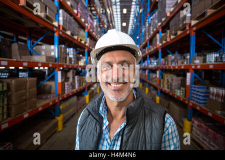Portrait of smiling warehouse worker wearing hard hat Stock Photo