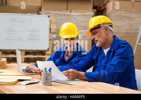 Warehouse workers discussing with each other Stock Photo