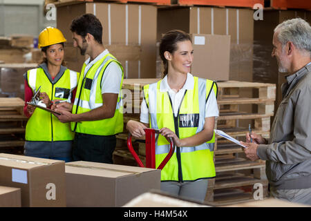 Warehouse manager and workers preparing a shipment Stock Photo
