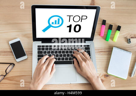 Top 10 list website on the screen of laptop computer with hands typing on keyboard Stock Photo