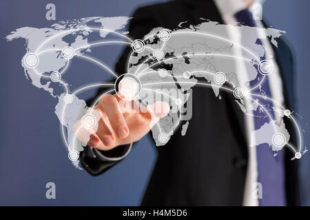 Social networks are worldwide as shown by a businessman on a world map touch screen Stock Photo