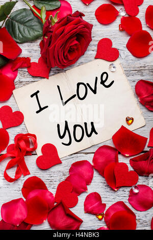 I love you card on wooden board with petals Stock Photo