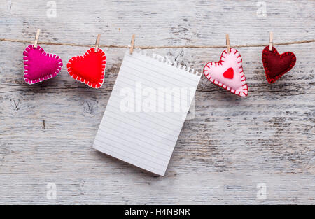 Felt handmade hearts and blank paper hanging on rope Stock Photo