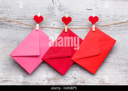 Envelopes hanging on a clothesline with wood background Stock Photo