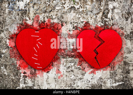 Pair of red broken hearts on aged wall texture Stock Photo