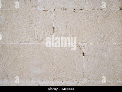 Traditional white stone wall. Detail of a wall made of white limestone bricks. Visible traces of chisel. Stock Photo