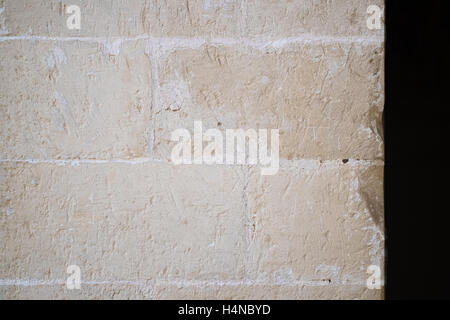 Traditional white stone wall. Detail of a wall made of white limestone bricks. Visible traces of chisel. Stock Photo