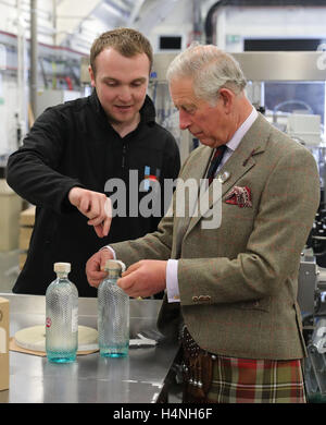 The Prince of Wales, known as the Lord of the Isles while in the Western Isles, puts a the label on a bottle of gin during a visit to the Isle of Harris Distillery, which he officially opened in Tarbert on the Isle of Harris. Stock Photo