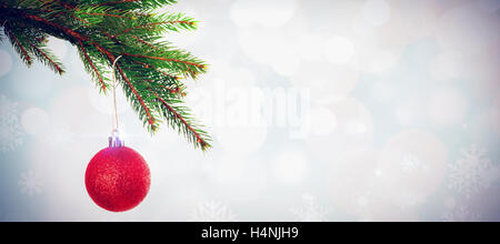 Composite image of red christmas bauble hanging from branch Stock Photo