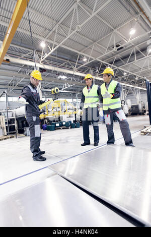 Workers working with aluminium billets at CNC machine shop Stock Photo