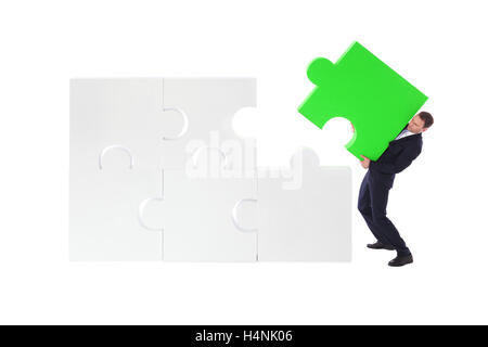 Business man assembling jigsaw puzzle isolated on white background Stock Photo