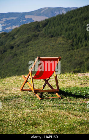 View at red easy chairs on the meadow at mountain Stock Photo