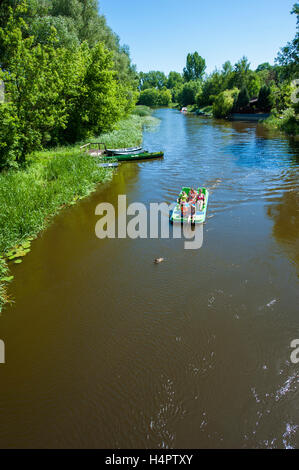 A channel of Narew river flowing through Pultusk, a historical town in Mazovia district of Poland. Vacationers on a paddle boat. Stock Photo