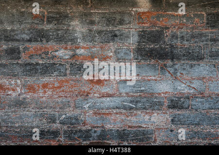 Antique brick wall with red bricks showing though layers of gray paint. Abstract background of building fragment in Toulouse, Fr Stock Photo