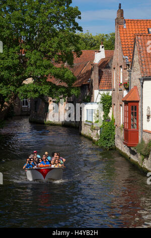 Tourists enjoying a city canal cruise in Bruges, Belgium Stock Photo