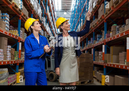 Warehouse manager and worker checking the inventory Stock Photo