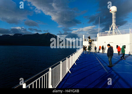 Tourists on ferry boat approaching the eastern Fjord coastline, Iceland, North Atlantic, Europe Stock Photo