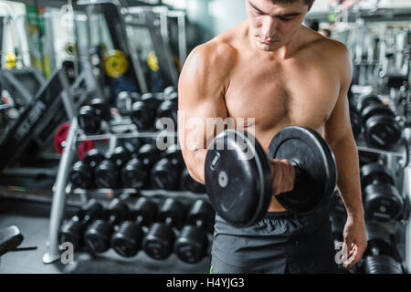 Muscular man exercising with barbell in gym Stock Photo