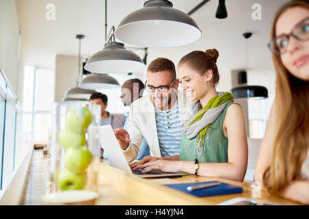 Young man showing his colleague something creative in the net Stock Photo