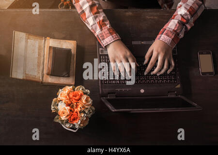 Women who are working on the old wooden table with a notebook. Stock Photo