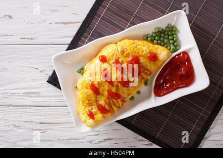 Japanese Omurice omelet stuffed with rice and chicken on a plate. horizontal top view Stock Photo