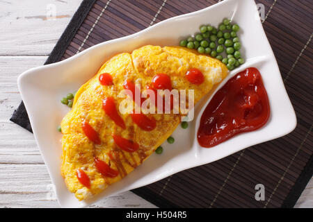 Japanese Omurice omelet stuffed with rice and chicken close-up on a plate. Horizontal top view Stock Photo