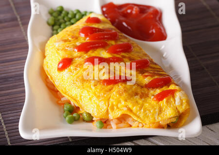 Delicious Japanese omelet stuffed with rice and chicken close-up on a plate. horizontal Stock Photo