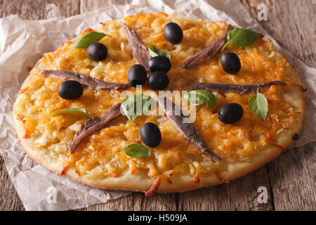 Homemade French pizza Pissaladiere with anchovy fillets, olives and onion close-up on the table. horizontal Stock Photo