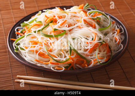 Chinese noodles with cucumber and carrot on a plate close-up. horizontal Stock Photo
