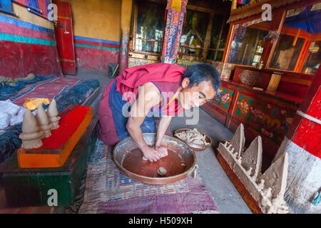 Young monk in Lhatse Chode Monastery is making torma cake. Stock Photo