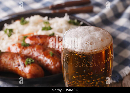 Lager beer close-up on a background of snack sausages and sauerkraut. horizontal Stock Photo