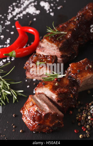 Spicy pork ribs BBQ closeup on the table with the ingredients. vertical Stock Photo